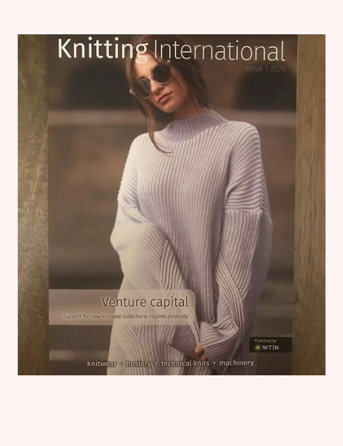 Front cover image of Knitting International showing a woman wearing an oversized cream jumper