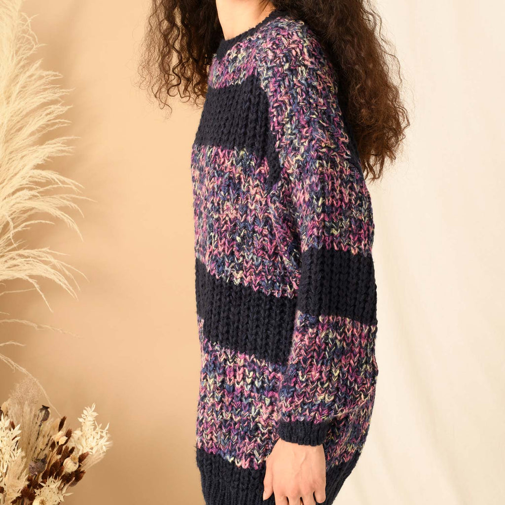 Close up of a navy blue and multi colour jumper